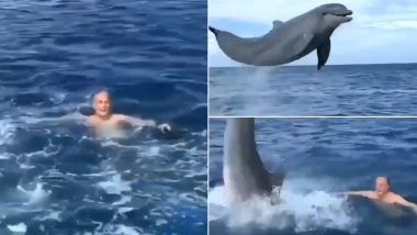 Man Swims With Dolphin: डॉल्फिन के साथ समुद्र में तैराकी का लुत्फ उठाते शख्स का वीडियो हुआ वायरल, देखें दिल को लुभाने वाला यह नजारा