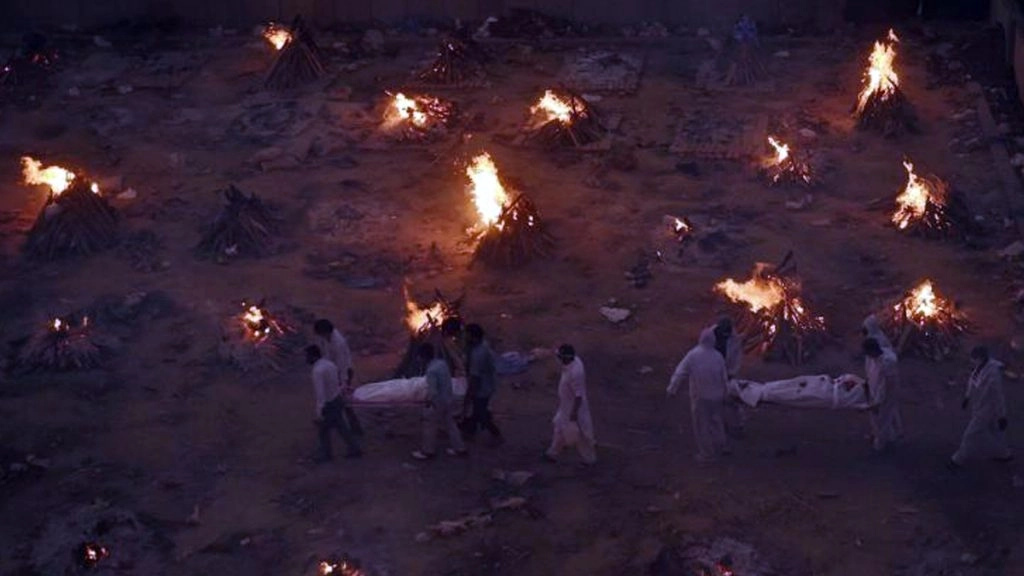 कफन में लिपटी यूं ही छोड़ दी गई लाशों का अंतिम संस्कार कर रहे अंजान लोग