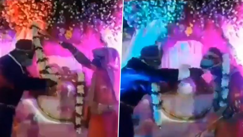 सोशल डिस्टेंसिंग का दूल्हा-दुल्हन ने निकाला गजब का जुगाड़, एक-दूसरे को ऐसे पहनाई वरमाला (Watch Viral Video)
