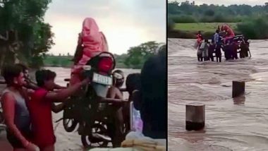 VIDEO: पहले महिला को बाइक पर बिठाया, फिर Bike को कंधे पर उठाया, बाढ़ में देखें कैसे पार कराई नदी