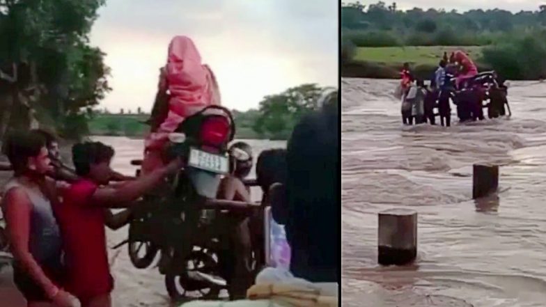 VIDEO: पहले महिला को बाइक पर बिठाया, फिर Bike को कंधे पर उठाया, बाढ़ में देखें कैसे पार कराई नदी