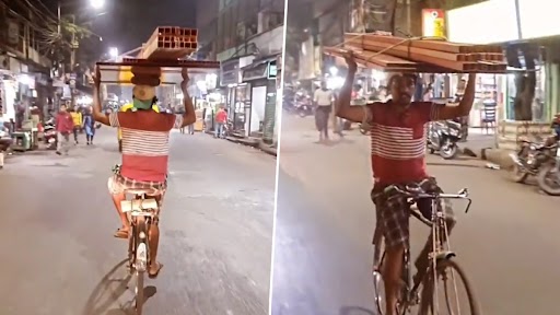 Viral Video: सिर पर प्लायवुड का बोझ लिए हुए और हैंडल छोड़कर साइकिल चलाते हुए शख्स का वीडियो वायरल