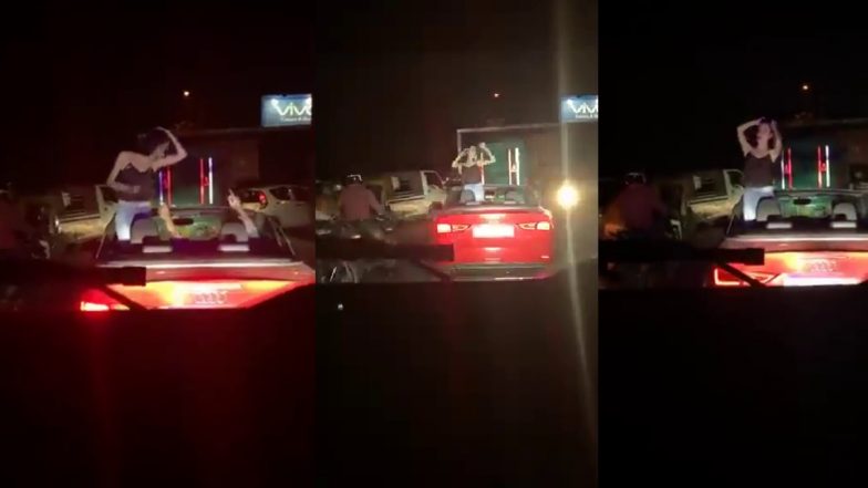 Noida: चलती कार में खिड़की के बाहर बैठे युवक का स्टंट, वीडियो वायरल होने पर जांच शुरू